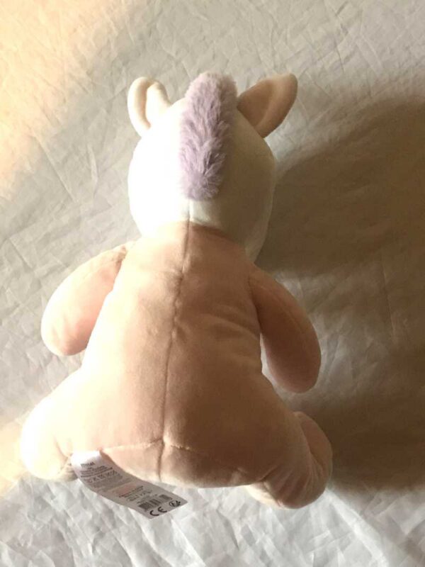 Arrière peluche normale licorne assise vêtement rose corne violette pailletée