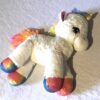 Côté peluche normale petite licorne blanche crinière queue pattes multicolores